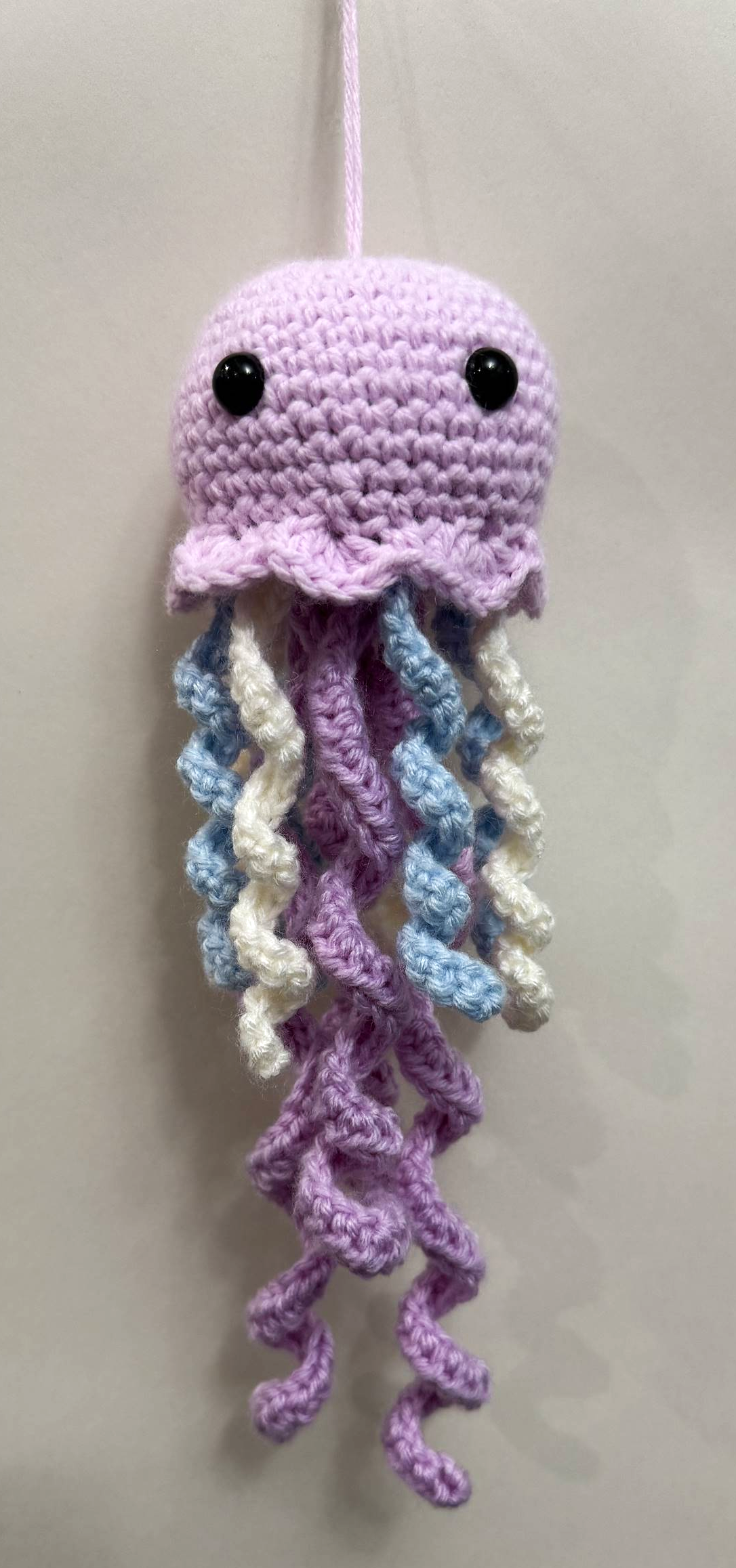 Yarn artwork with long tentacle-like strands in varied colors.